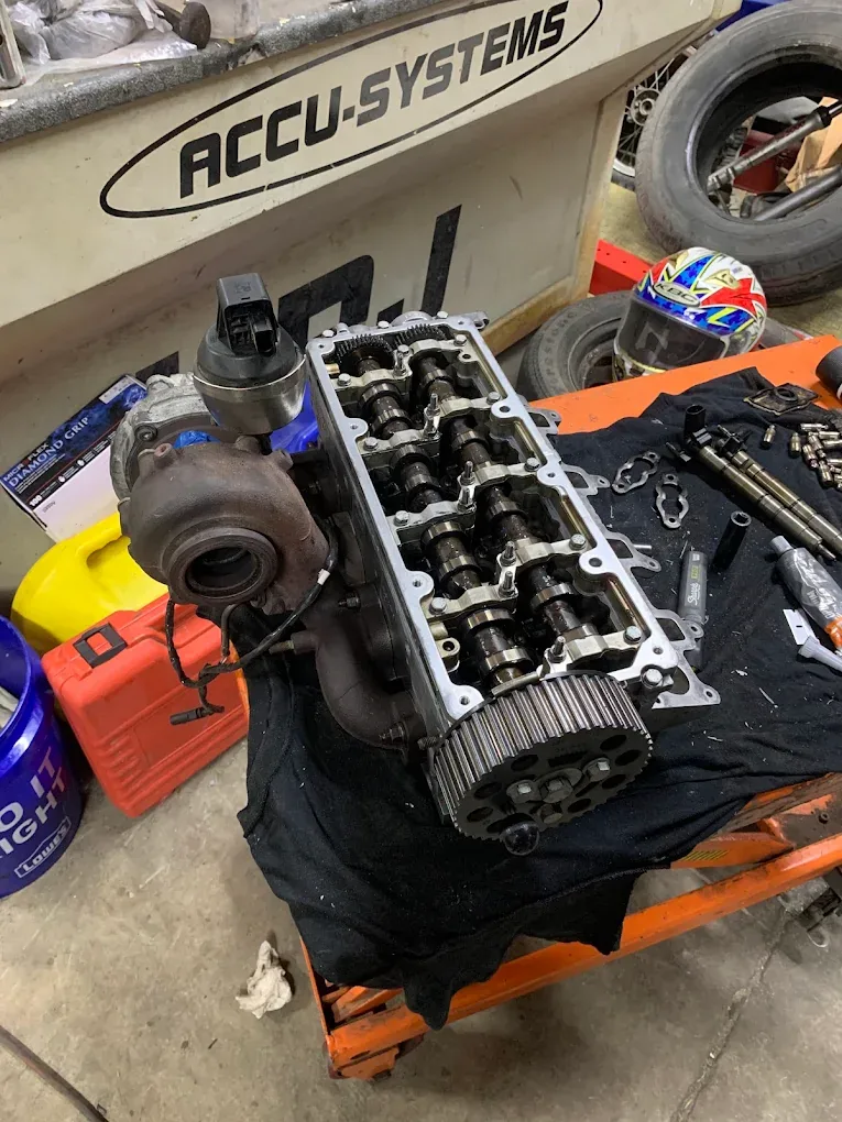 Automotive cylinder head and engine parts on a workbench
