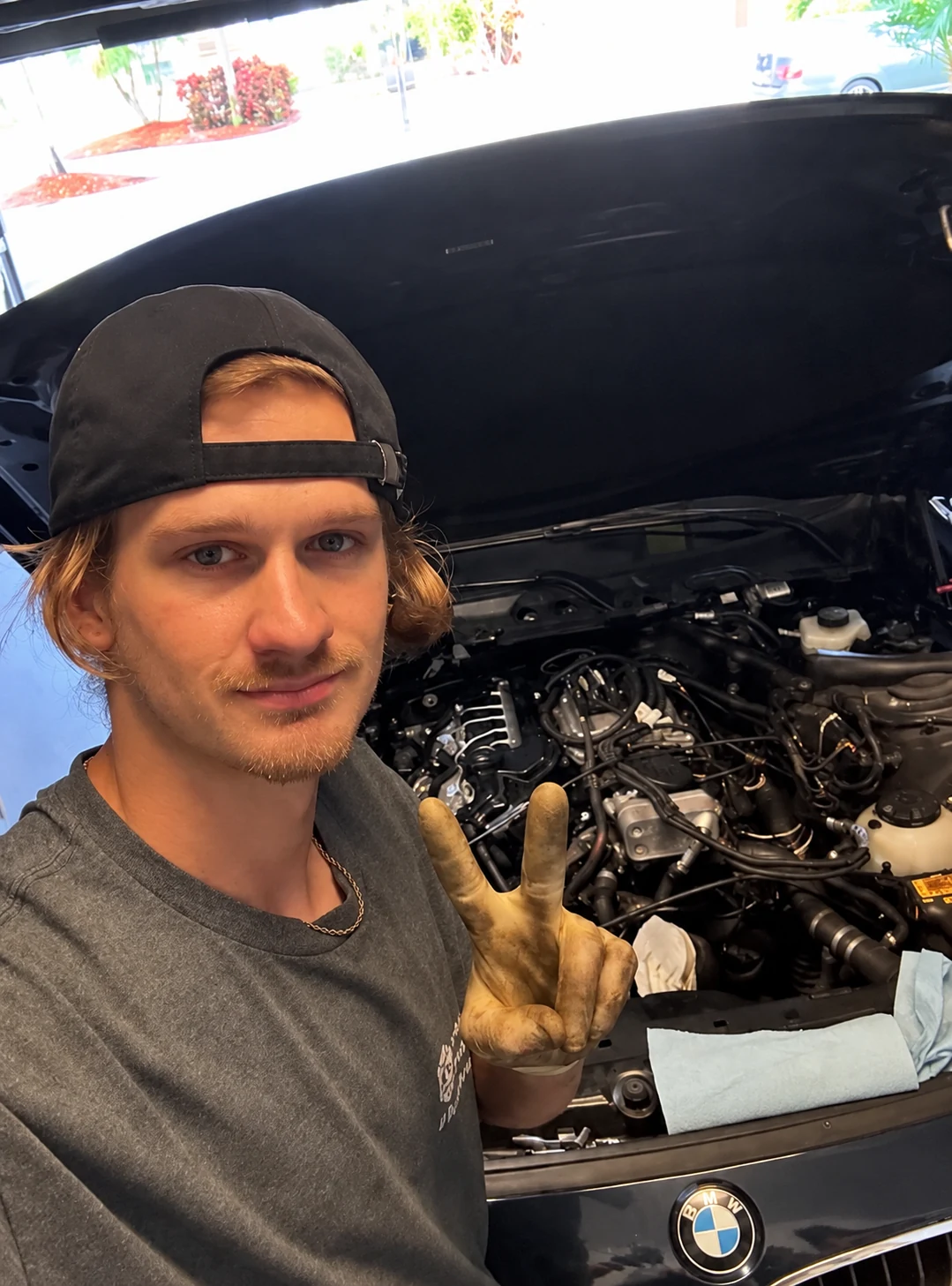 Kasan working on a BMW with its hood open